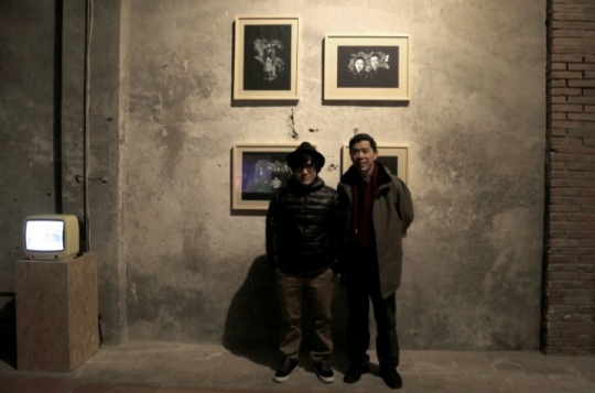 艺术家雷磊和他的父亲在开幕现场，背后是雷磊父亲的作品
