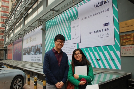 策展人王浩臣（左一）与友人在美术馆门前海报合影
