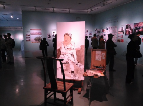 在图文展示忻东旺生命历程的展厅中央放置的未完成的画作
