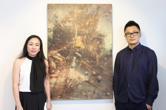 艺术家闫占城（右）、圣东方艺术画廊董事长周鸣（左）在参展作品前
