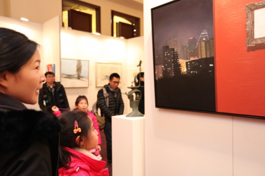 观众在展览现场凝视青年艺术家的作品
