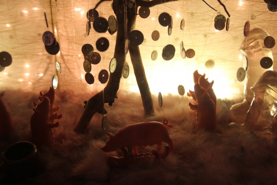 硬币树、塑料猪、玻璃阳具，在金黄色灯光的笼罩之下，派生出了奇幻世界的景象
