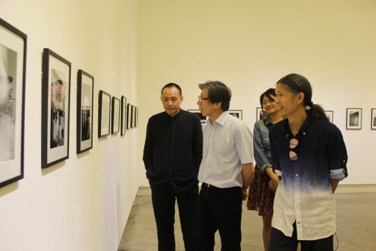三影堂摄影艺术中心创始人荣荣（右一）与嘉宾中央美术学院院长范迪安（左二）观看展览
