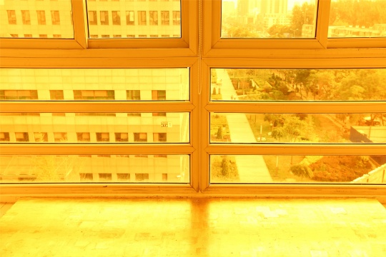阳光透过窗户的暖色玻璃纸进入房间，与地面相映成辉
