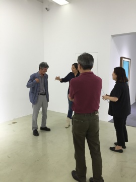 艺术家姜尧培（远处左一）向来宾介绍展览作品

