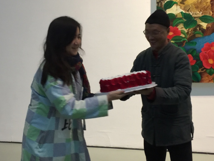 “上世纪”个展开幕，吕胜中接过实验艺术学院青年教师、艺术家叶甫纳送来的蛋糕
