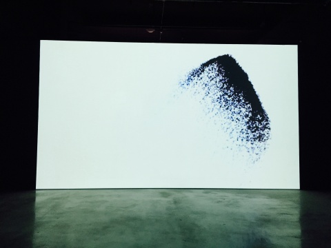 成都当地艺术家李琨2012年声音影像视听装置作品《“真实”的维度I》，影像中的图像如飞沙舞动
