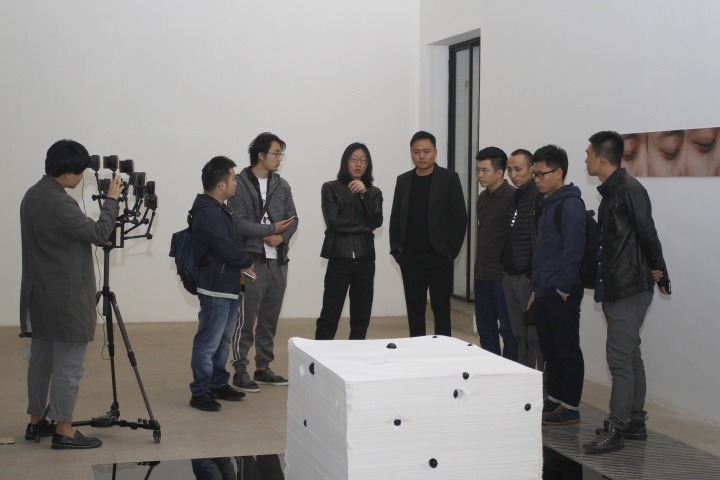 策展人朱朱（左三）和艺术家伍伟（左四）现场为媒体做导览
