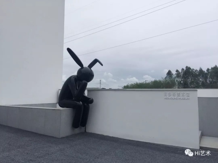 何多苓美术馆的院墙上坐着一只纯黑色“大兔子”，它也是区别于美术馆白色之外的唯一颜色。那是何多苓仿罗丹的《思想者》做的雕塑，他说纯粹做着好玩，不算正经作品
