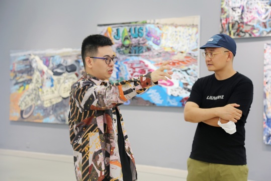 艺术家陈轩荣（左一）在展览现场
