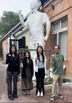 观众与策展人王春辰在雕像前合影

