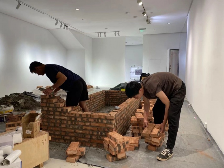  

郭定奋在罗中立美术馆“明天雕塑奖“展览中砌墙

左：郭定朋（郭定奋表哥） 右：郭定奋
