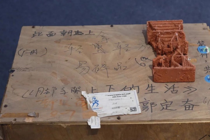 《脚手架上下的生活》 尺寸可变

电子相框、红砖、砖坯、宣纸画卷 2020

“2020年12月10日，在大学毕业前，我踏上了前往

海南省海口市东山仔村工地的旅程，跟随堂哥堂嫂们在工地上

度过了半年的工作和生活时光。在这段时间里，

我不仅亲身体验了工地生活，

还记录了族人们的工地生活和背后的家庭故事，

更有幸追溯到了父辈们工地生活的痕迹，

以及探究了导致乡村儿童留守现象的相关原因。”
