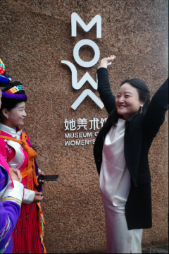 她美术馆馆长罗怡博士向当地参加共创的摩梭姐妹说明MOWA的LOGO的含义是女性拥抱大地、托起蓝天
