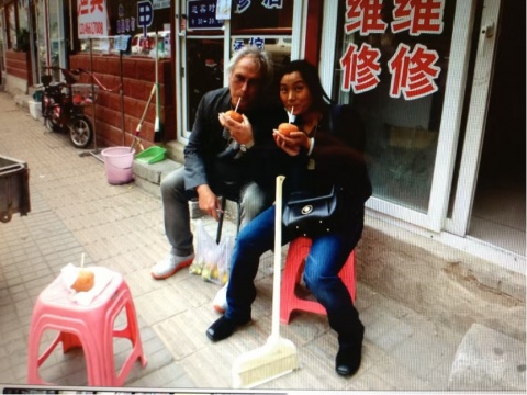 2011年跟艾瑞克·费舍尔在花家地美院旁的小集市用吸管品尝冻柿子In 2011, Lu Yun tasted frozen persimmons with a straw together with Eric Fischl at the small market beside the Central Academy of Fine Arts in Huajiadi.